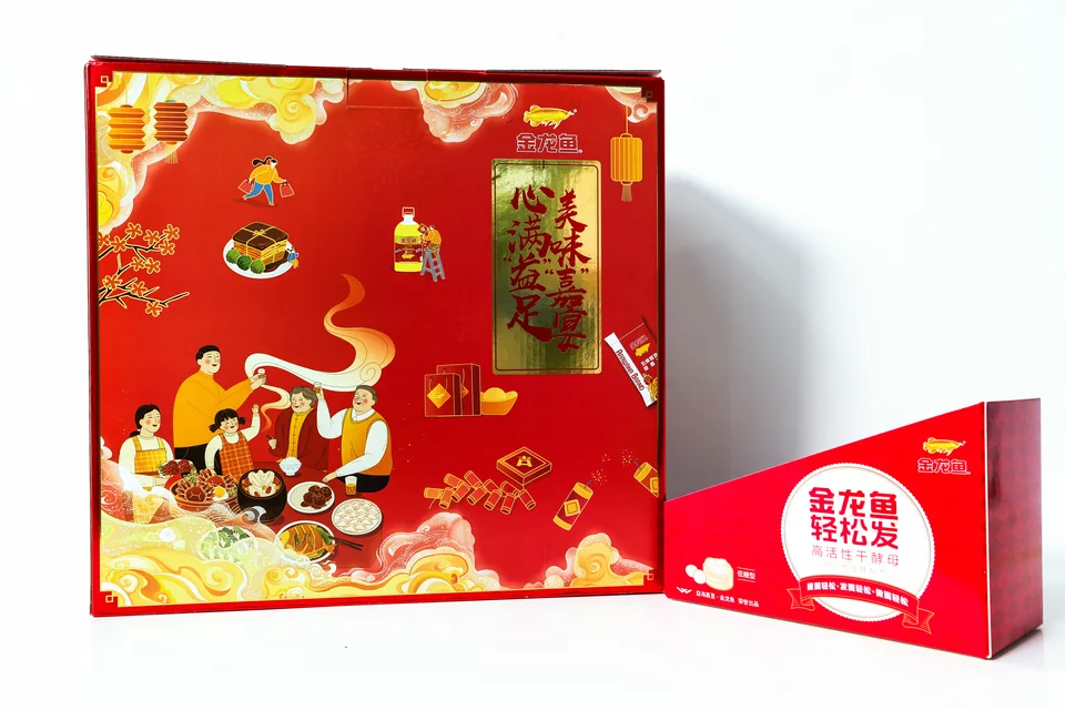 金龙鱼节庆食品礼盒实拍；红金配色礼盒搭配独立小盒，以节庆图案和品牌图文形成组合。
